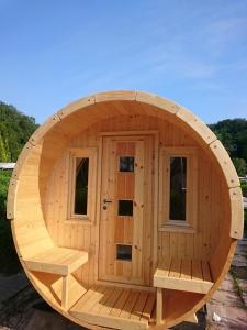 a circular wooden sauna with a bench in it at Schlaffass in Wittenborn