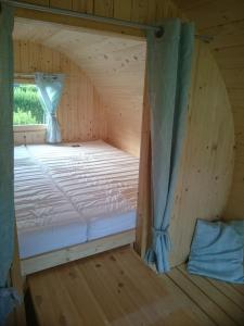 a bed in a wooden room with a window at Schlaffass in Wittenborn
