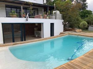 a large swimming pool in front of a house at Hout Bay Holiday House in Hout Bay