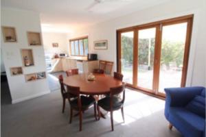 un soggiorno con tavolo e sedie in legno di Lighthouse Retreat - Pet Friendly Free Wifi a Apollo Bay