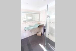 a bathroom with a blue sink and a shower at Lighthouse Retreat - Pet Friendly Free Wifi in Apollo Bay