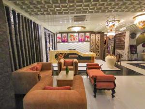 a living room with couches and chairs and a piano at Ghar 365 Residency in Guwahati