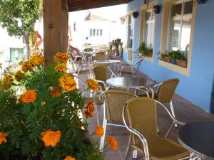 an outdoor patio with tables and chairs and orange flowers at Posada La Maza in Arnuero
