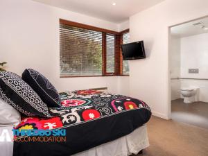 a bedroom with a bed and a television in a room at Elevation 5 in Thredbo