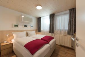 a bedroom with a large white bed with a red blanket at Fewo Nachbaur Typ A1 in Oberjoch