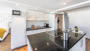 a kitchen with white cabinets and a black counter top at Boutique Hotel St. Georg in Einsiedeln