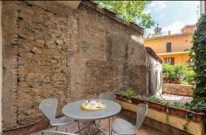 a patio with a table and chairs on a brick wall at Ghetto Apartment with balcony in Rome