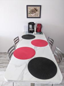 ein weißer Tisch mit roten und schwarzen Sonnenschirmen darauf in der Unterkunft Joli F2 Saint Endreol HAMEAU PALAYSON Var in La Motte