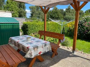 a table and a bench under a gazebo at Ferienwohnung Thees in Ummanz