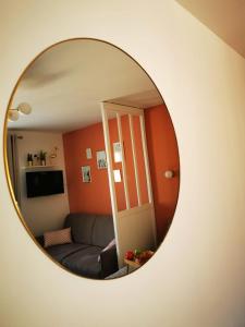 a mirror reflecting a living room with a couch at Petit Quai - Studio entièrement rénové plein centre Trouville in Trouville-sur-Mer