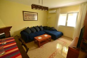 un soggiorno con un divano blu e un tavolo di Villa Isabelita a Torremolinos