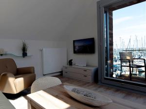 a living room with a large window with a view of a harbor at Ostsee - Appartement Nr 50 "Meerblick" am Yachthafen im Strand Resort in Heiligenhafen