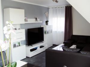 La Domus Premium في Lotte: غرفة معيشة مع أريكة سوداء وتلفزيون بشاشة مسطحة