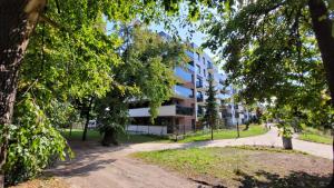 Apartamenty Przy IV Śluzie - Green في بيدغوشتش: مبنى في وسط حديقة فيها اشجار