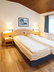 1 cama grande en un dormitorio con 2 lámparas en Eifelblick über dem See en Biersdorf