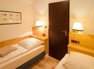 niewielka sypialnia z 2 łóżkami i 2 lampami w obiekcie Eifelblick über dem See w mieście Biersdorf