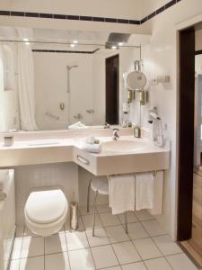 biała łazienka z umywalką i toaletą w obiekcie Eifelblick über dem See w mieście Biersdorf