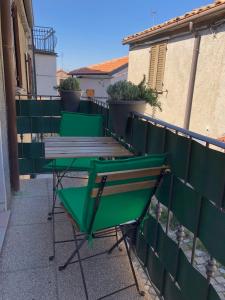 a group of green tables and chairs on a balcony at da Susanna in Perticara