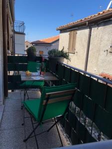 a group of green chairs and a table on a balcony at da Susanna in Perticara