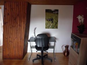 a black chair in a room with a picture on the wall at Wohnung in der "Alten Post" in Hohenhameln