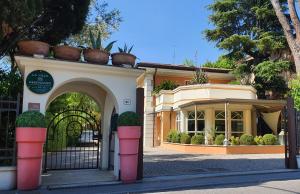una entrada a un edificio con macetas en la parte superior en La Villa Desenzano, en Desenzano del Garda