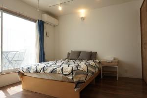 藤沢市にあるBart Inn Kugenuma Resortのベッドルーム1室(ベッド1台、大きな窓付)