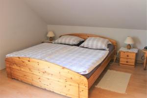 1 dormitorio con 1 cama de madera con 2 almohadas en "Pappelhof - Whg 6", en Grömitz