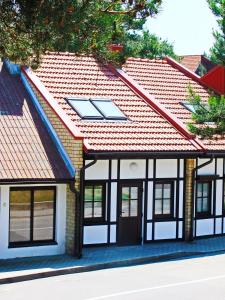 una casa con techo rojo en Irinos Apartamentai, en Nida