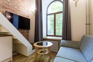 a living room with a couch and a chair and a window at City Center Loft Apartment in Tallinn