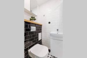 a bathroom with a white toilet and a sink at City Center Loft Apartment in Tallinn
