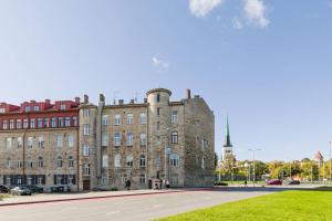 an old stone building with a grassy field in front of it at City Center Loft Apartment in Tallinn