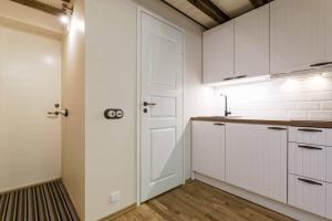a kitchen with white cabinets and a white door at City Center Loft Apartment in Tallinn +5 photos