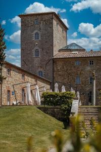 a large stone building with a clock on it at Borgo Scopeto Wine & Country Relais in Vagliagli