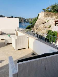 balcón con muebles blancos y vistas al agua en "Sweet Life" Casa Vacanze, en Lipari