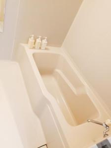 a bathroom with a bath tub with two toilets at Lodge 401 Niseko Annupuri in Niseko