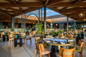a dining room with tables and chairs and a restaurant at Stella Palace Aqua Park Resort in Hersonissos