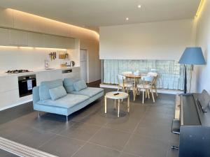 sala de estar con sofá azul y mesa en Nishi Holiday Apartments en Canberra