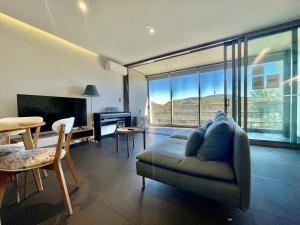 a living room with a couch and a table at Nishi Holiday Apartments in Canberra