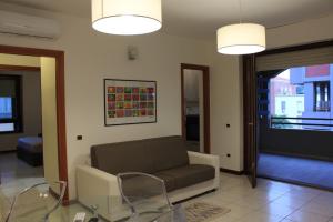 ein Wohnzimmer mit einem Sofa und einem Glastisch in der Unterkunft Poetto Beach in Cagliari