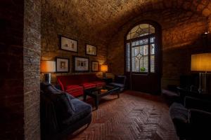 sala de estar con sofá rojo y ventana en Borgo Scopeto Wine & Country Relais, en Vagliagli