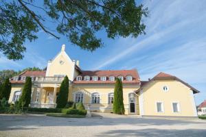 a large white house with a red roof at Rosenberg Kúria in Táplánszentkereszt