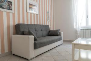 a couch sitting in a living room with striped walls at Maison M, Terre Marine in San Terenzo