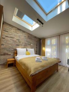 1 dormitorio con 1 cama grande y pared de ladrillo en Starowiślna 41-43 by PI Apartments en Cracovia