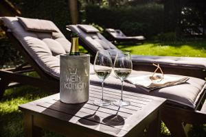 Hotel Kronenschlösschen في إلتفيل: طاولة مع كأسين من النبيذ وزجاجة من النبيذ