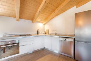 萊里奇的住宿－Punti di Vista, Terre Marine，厨房配有白色橱柜和木制天花板