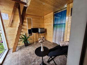 een woonkamer met een tafel en een televisie bij #1 cabin Tiny house with kitchen equipped with essentials near at the Volcano Park in Pahoa