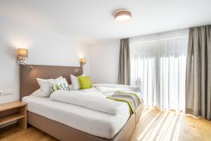 Un pat sau paturi într-o cameră la Edelweiss Apartments 200m zum Lift