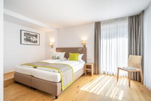 una camera d'albergo con un letto e una finestra di Edelweiss Apartments 200m zum Lift - Silvretta Card Premium Inklusive a See