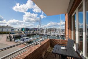 a balcony with a table and a view of a marina at ancora Marina Haus 2 Nr 04, Typ 1 in Neustadt in Holstein