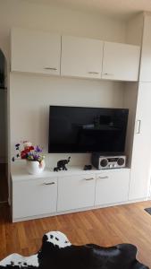 a large white entertainment center with a flat screen tv at Am Ufersteig-I in Verchen